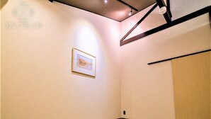 Una habitación con un cuadro enmarcado en la pared, una puerta de madera y un piso a cuadros.
