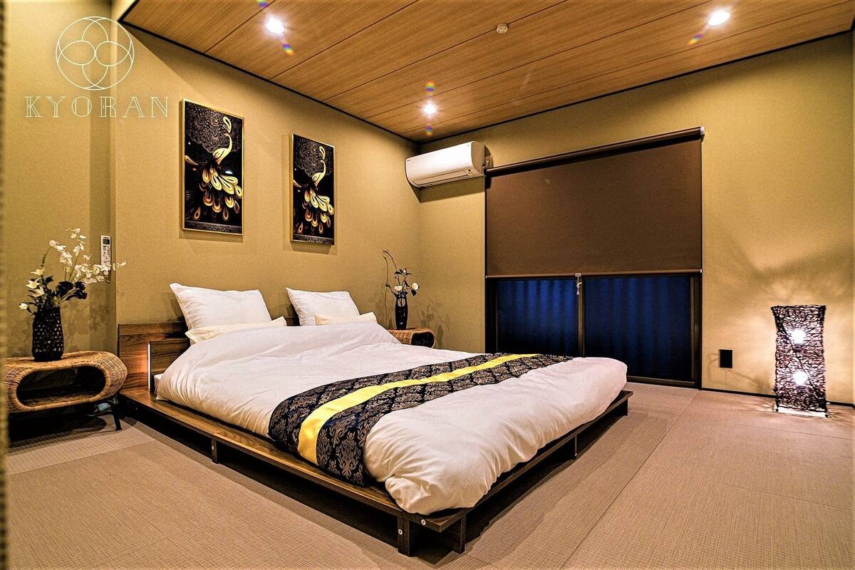 Ein modernes Schlafzimmer mit einem großen Bett, zwei Wand-Klimaanlagen und einer Schiebetür.