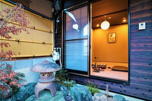Een traditionele Japanse kamer met tatami vloerbedekking, een shoji-scherm en een stenen lantaarn.