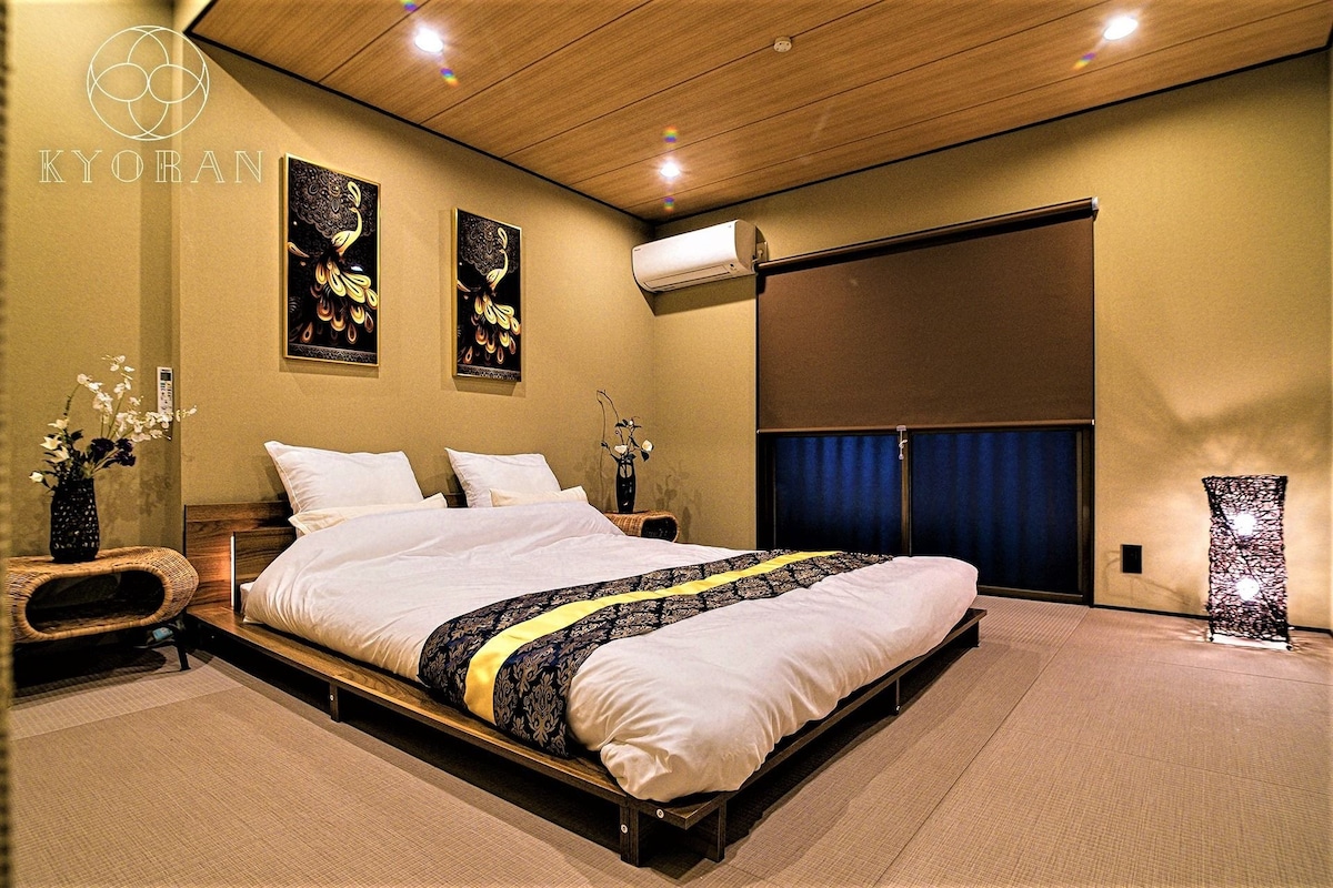 Een moderne slaapkamer met een groot bed, twee wandairconditioners en een schuifdeur.