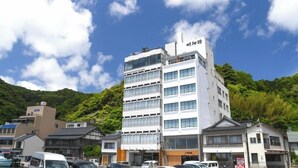 Un edificio de varios pisos con un diseño moderno, que presenta un techo plano y amplios ventanales.