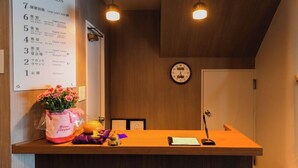 Una recepción con un reloj, un tablón de anuncios y una decoración floral.