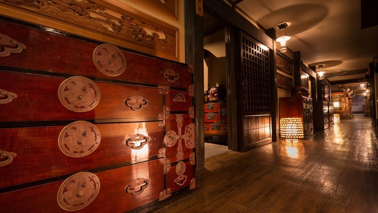 A hallway with wooden cabinets, a traditional door, and a patterned ceiling.
