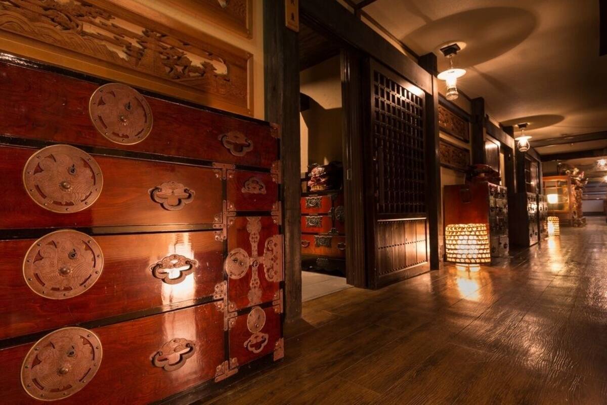 Um corredor com armários de madeira, uma porta tradicional e teto com padrão.
