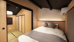 Habitación de hotel con cama, armario, ventilador de techo y ventana con persianas.