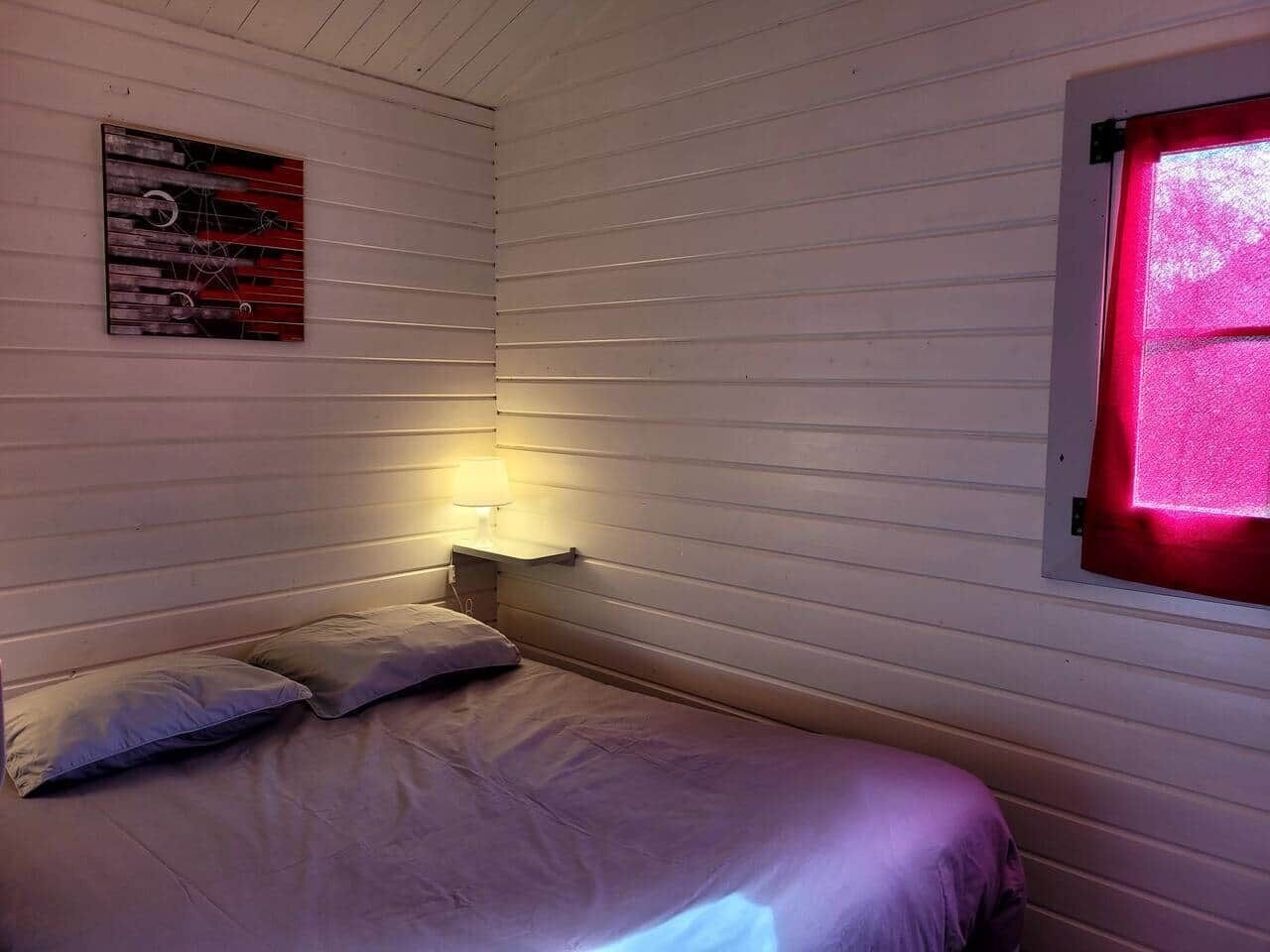 A single bed with a headboard, a bedside lamp, and a wall-mounted artwork.