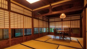 Ett traditionellt japanskt rum med tatamimattor på golvet, skjutbara shojidörrar och ett lågt tak.