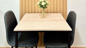 Una cita enmarcada en una pared, una mesa con un florero y dos sillas.