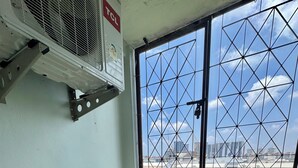 Una habitación con ventana, ventilador de techo y una tubería de agua visible.