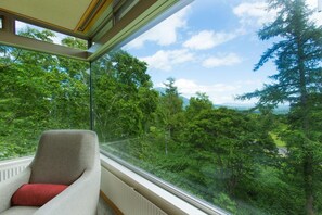 A room with a large window overlooking a forested area. - The Green Leaf Niseko Village, Tapestry Collection (Niseko)