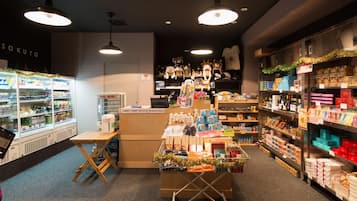 Interior de una tienda con mostrador de exhibición, estanterías llenas de productos y una sección refrigerada.