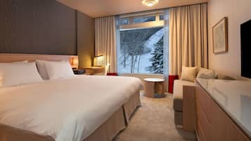 Una habitación de hotel con una cama grande, un escritorio con silla, una mesita redonda pequeña y un sofá.