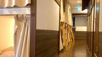 A hotel corridor with wooden flooring, a wooden door frame, and a wooden staircase.