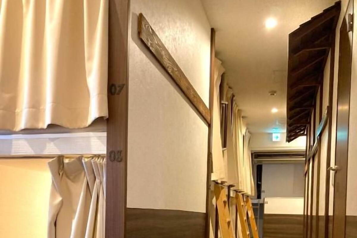 A hotel corridor with wooden flooring, a wooden door frame, and a wooden staircase.
