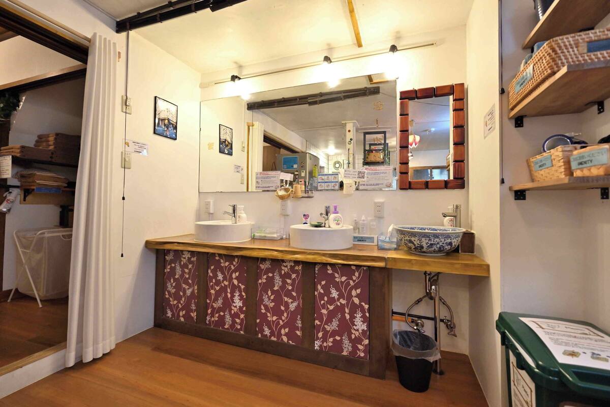 A bathroom with a wooden vanity, a large mirror, and a sink.