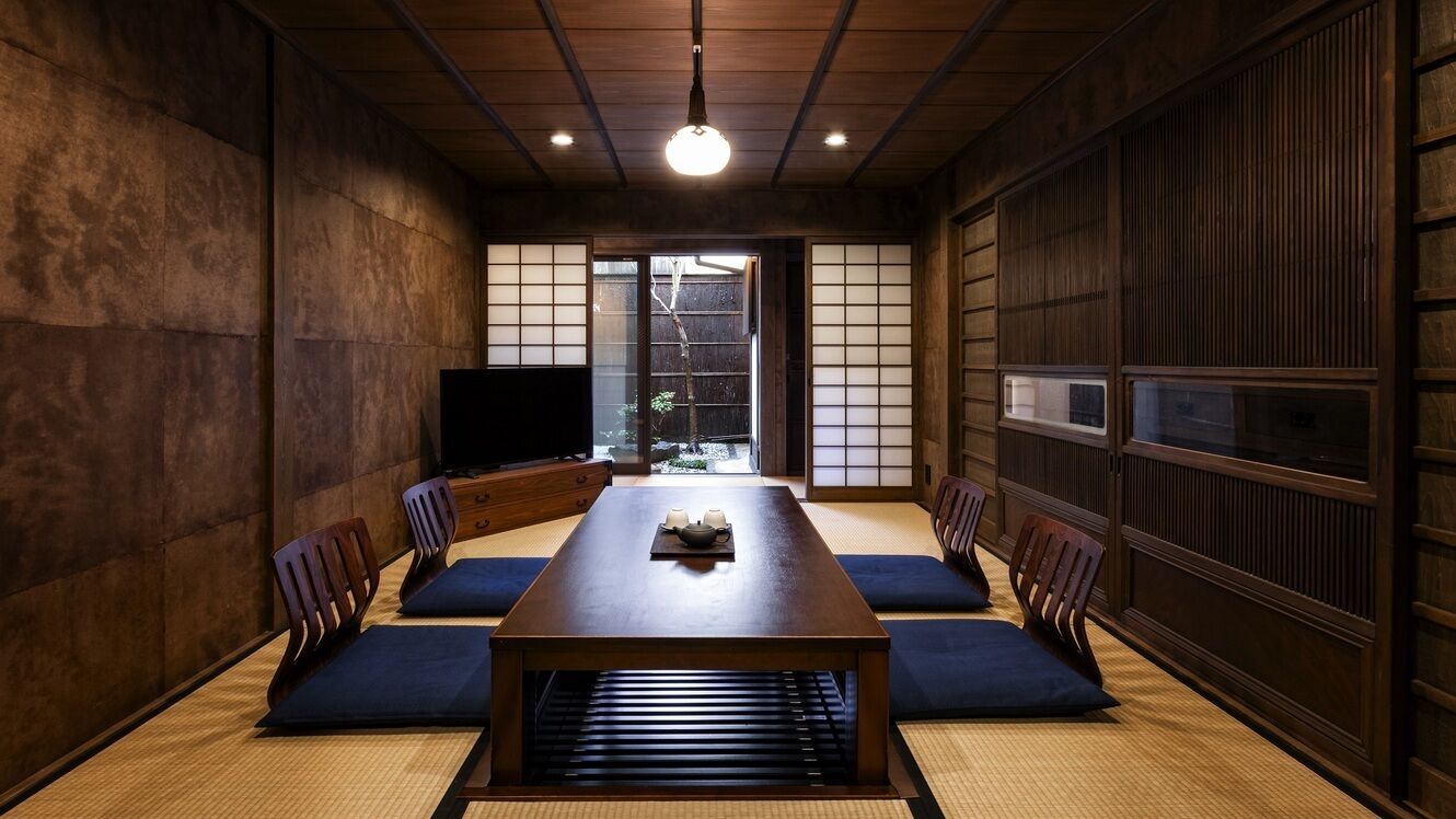 A traditional Japanese room with tatami mats, a low table, and sliding doors.