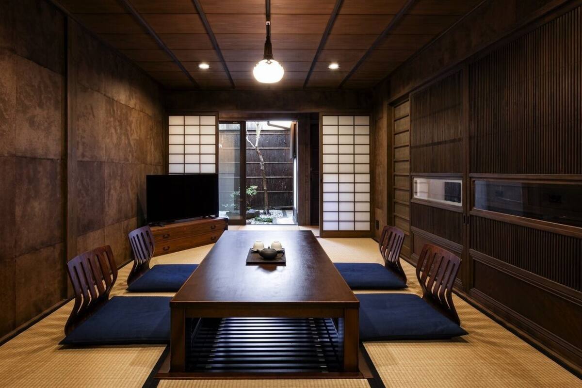 A traditional Japanese room with tatami mats, a low table, and sliding doors.
