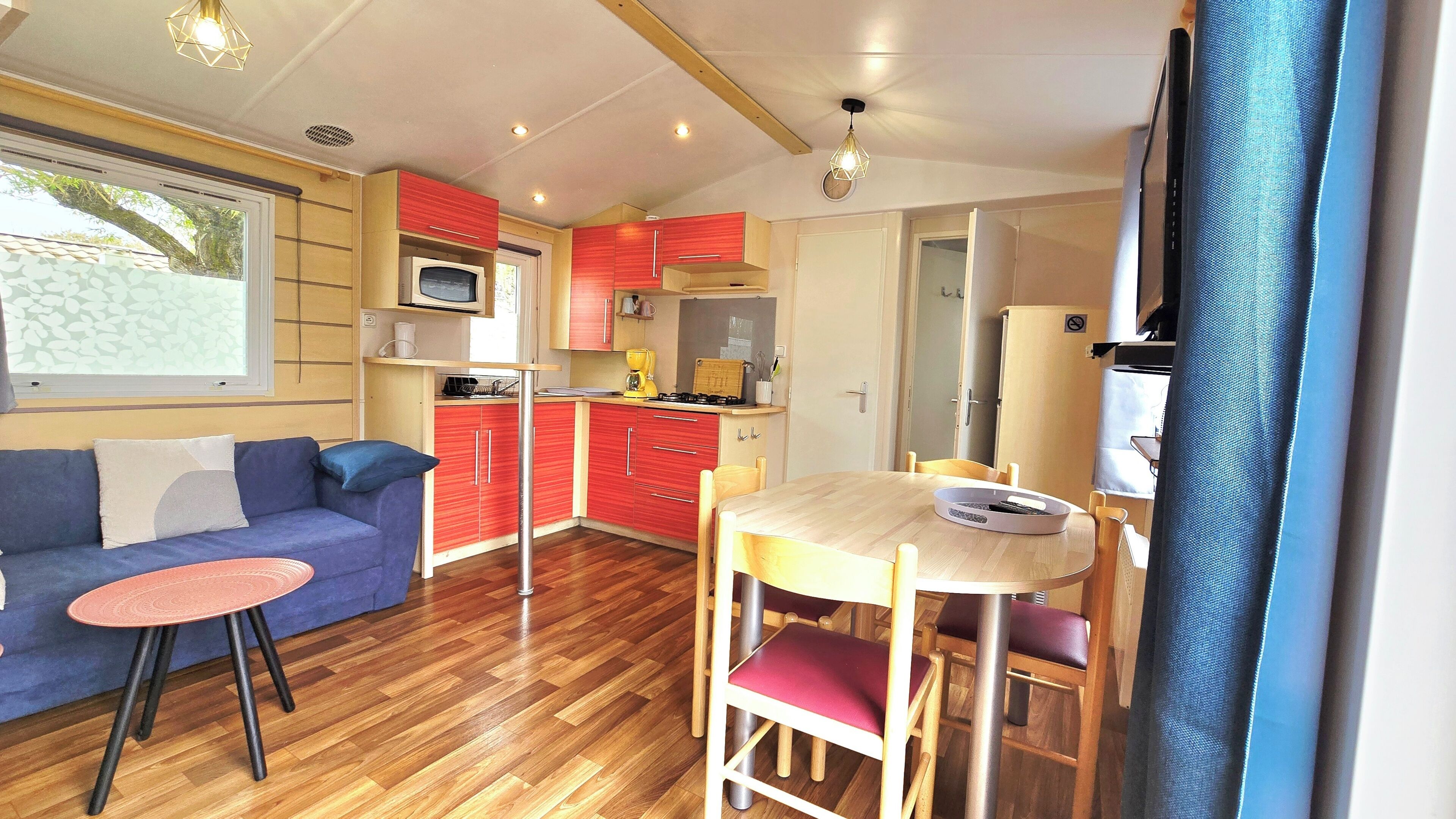 A compact living space with a kitchenette, a dining area, and a sofa.
