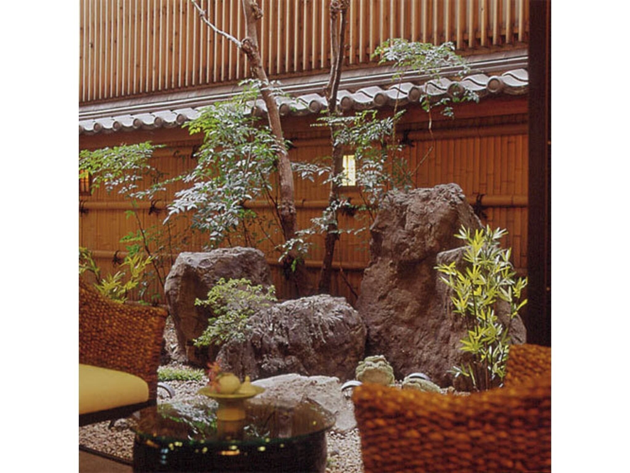 Ein traditioneller japanischer Raum mit Tatami-Böden, einem niedrigen Holztisch und einem Steingarten.