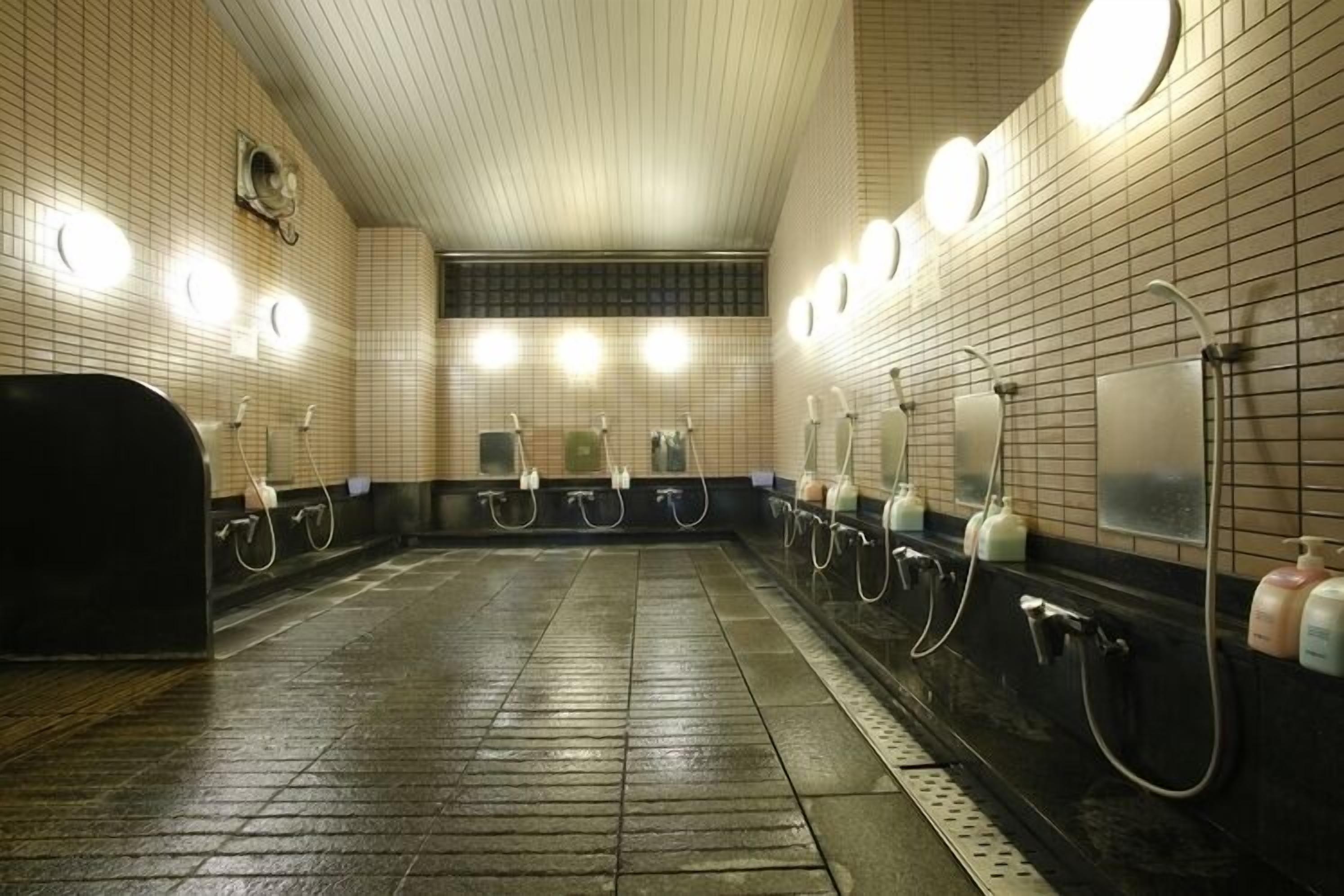 A public restroom with multiple sinks, hand dryers, and paper towel dispensers.