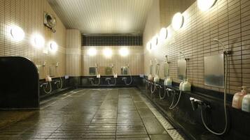 A public restroom with multiple sinks, hand dryers, and paper towel dispensers.