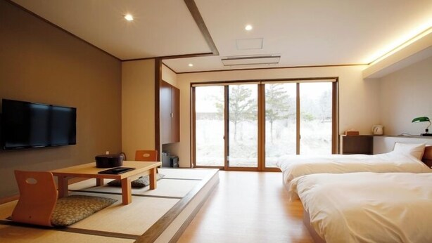 Una habitación de hotel moderna con una cama, un escritorio y un televisor.