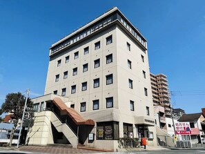 A multi-story building with a flat facade, multiple windows, and a visible entrance.