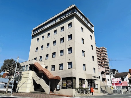 A multi-story building with a flat facade, multiple windows, and a visible entrance.