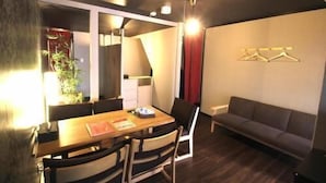 Una habitación moderna con una mesa de comedor, sillas, un sofá y un aplique de pared.