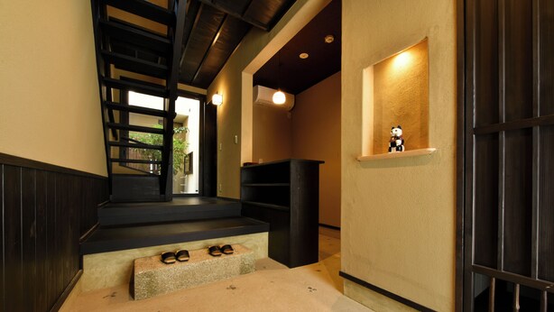 A staircase leading to a landing with a small shelf and a figurine. - Shibashi Umeyacho (Kyoto)