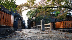 A traditional Japanese street with stone lanterns and wooden fences. - Tsumugi Horikawa Kichimonji (Kyoto)