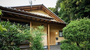 A traditional Japanese building with a tiled roof, wooden beams, and a lattice door. - Glampetit Koh (Atami)