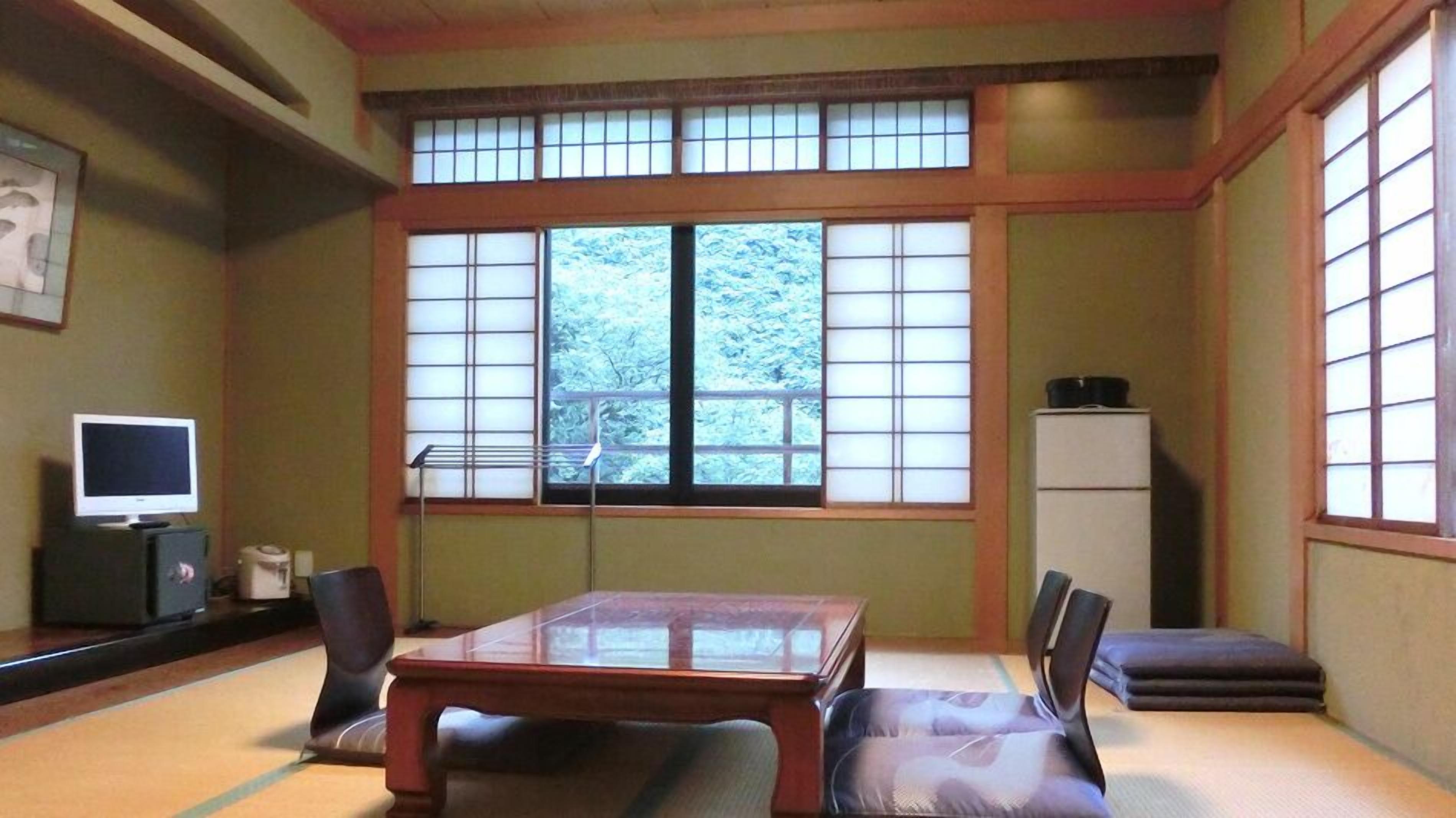 A traditional Japanese room with tatami flooring, a low table, and shoji screens.