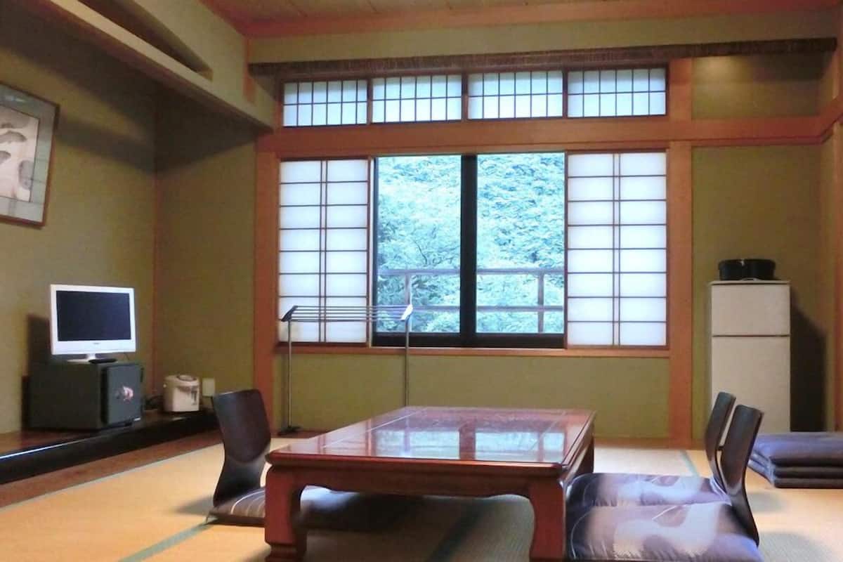 A traditional Japanese room with tatami flooring, a low table, and shoji screens.
