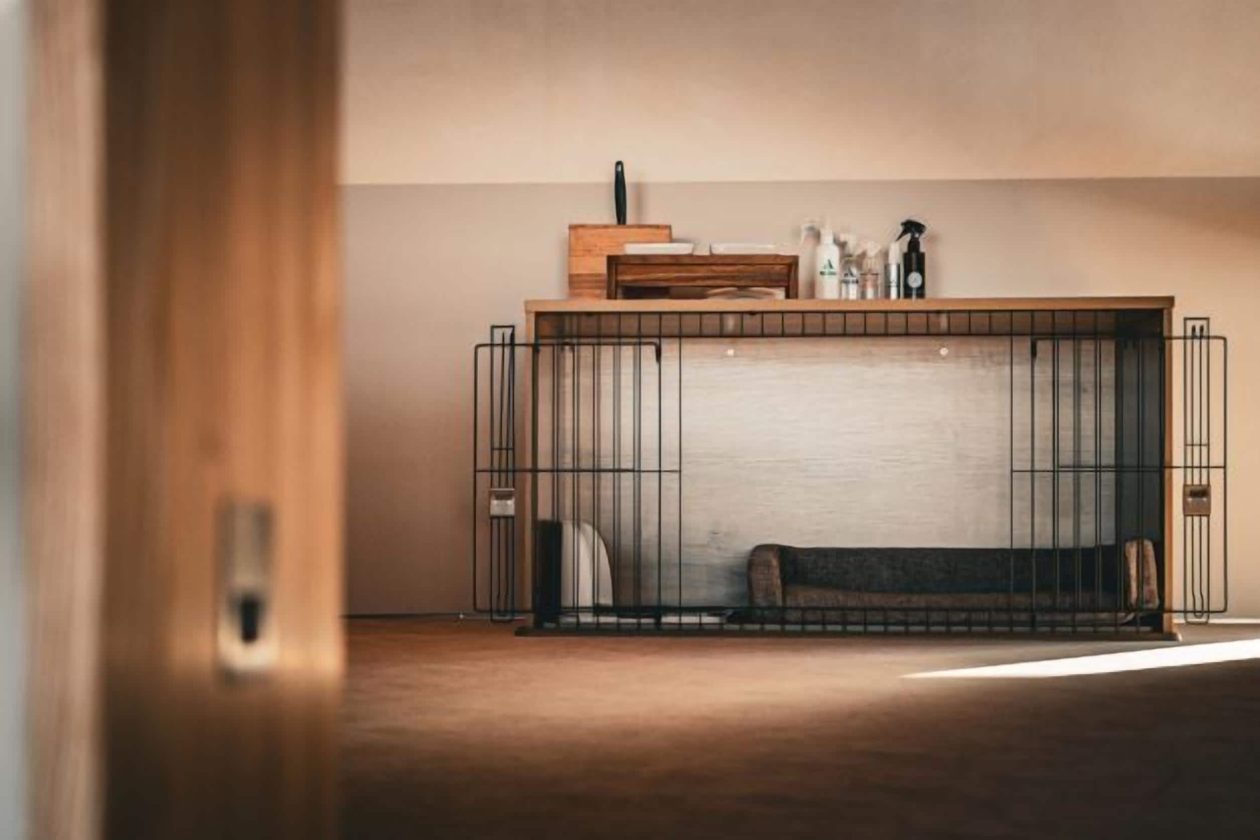Ein Zimmer mit Holzboden, einem Metallbettgestell, einem Holz-Kopfbrett und einem kleinen Tisch mit Lampe und Flaschen.