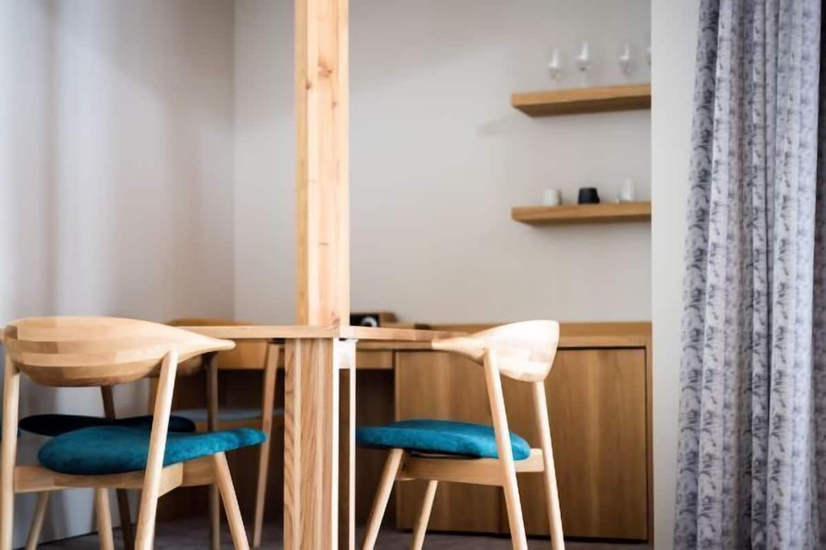 Una mesa de comedor de madera con dos sillas, cada una con un cojín azul.