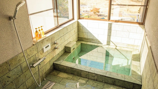A small, tiled bathroom with a shower, a window, and a view of the outside. - Maigre Fields (Atami)