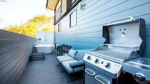 An outdoor patio with a grill, seating, and a small outdoor shower. - Maigre Fields (Atami)