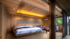 Un dormitorio de cabaña de madera con cama, una mesita y un sofá.