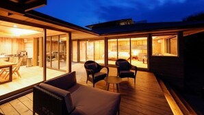 Una terraza al aire libre con comedor, sofá y sillones.