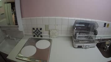 Una cocina con encimera blanca, una balanza, un tostador y un fregadero.