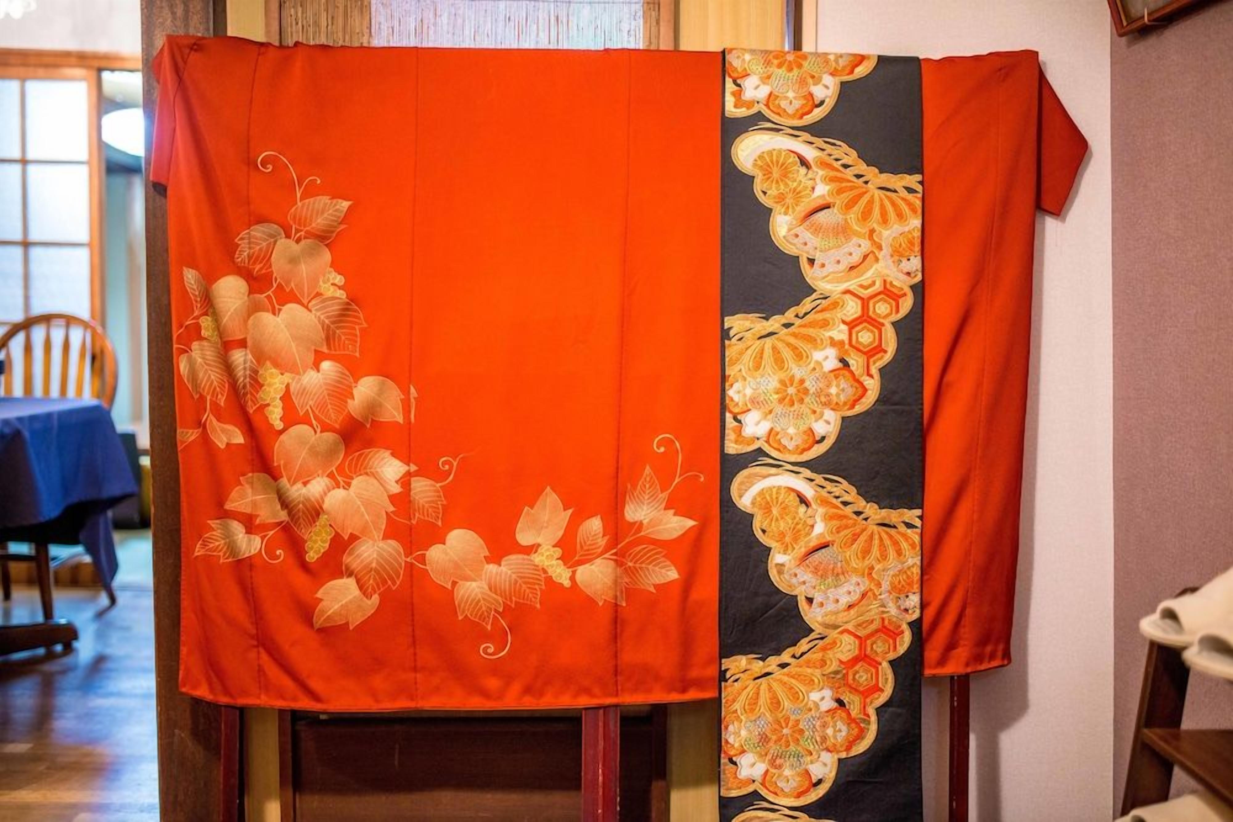 A room with a table and chairs, a window, and a wall with a decorative fabric.