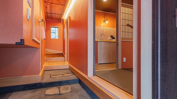 A narrow hallway with a wooden staircase leading to a room with a tiled backsplash and a window. - Yadoya Sen no Sato (Tokyo)