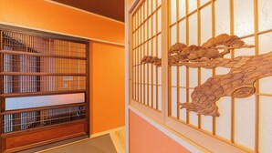 A traditional Japanese room with sliding doors and a decorative wooden panel. - Yadoya Sen no Sato (Tokyo)