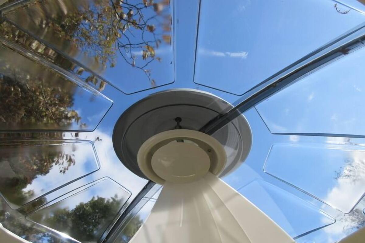 A ceiling with a central light fixture and multiple skylight panels.
