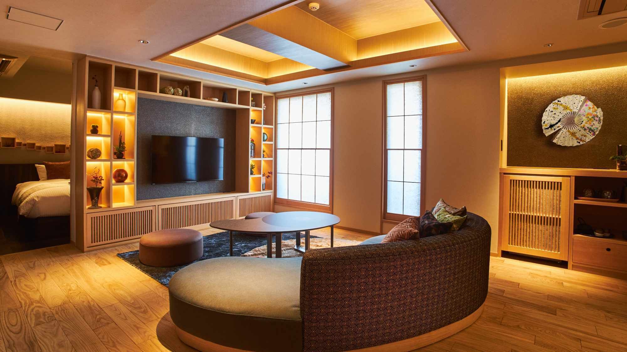 A modern living room with a TV, seating, and a large window.