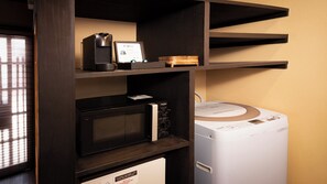 A kitchen with a microwave, a coffee maker, and a washing machine. - Rinn Gojo Mibugawa East (Kyoto)