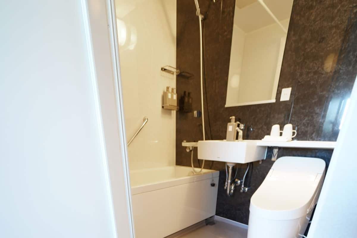 A modern bathroom with a bathtub, a sink, and a mirror.