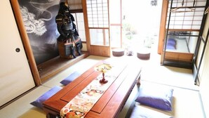 Um quarto japonês tradicional com tatames, uma mesa de madeira baixa e uma porta deslizante.