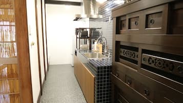A narrow kitchen with a tiled backsplash, a built-in oven, and a countertop with a sink.